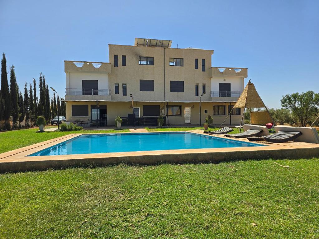 una casa con piscina di fronte a un edificio di Lina Village a Al Hachlaf