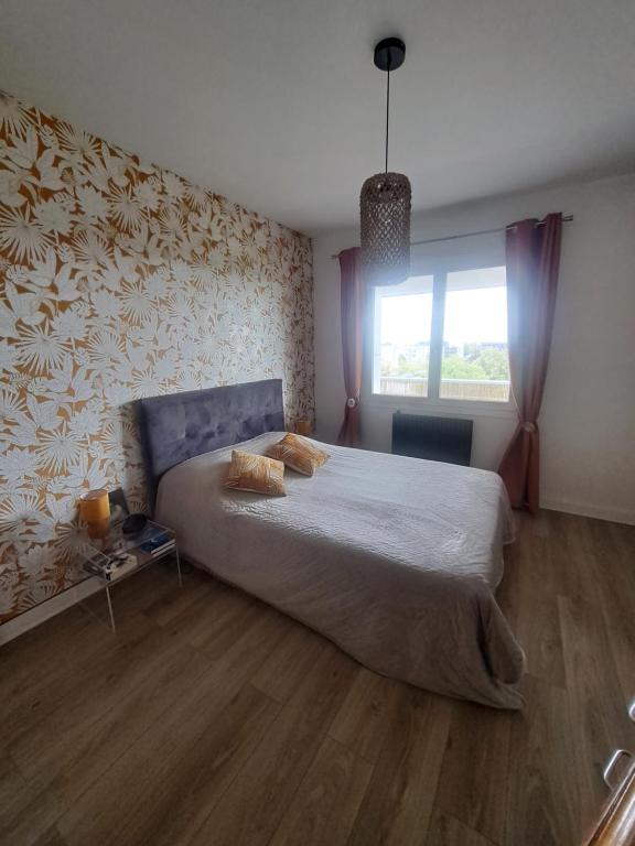 Un dormitorio con una cama grande y una ventana en Les grands prés, en Aytré