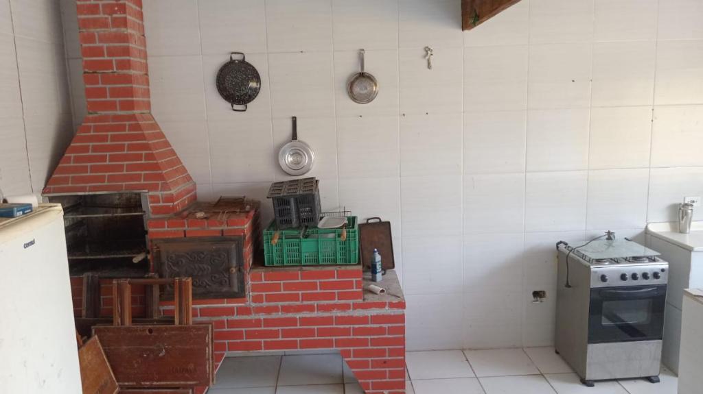 a kitchen with a brick oven in a room at Casa monguagua in Mongaguá