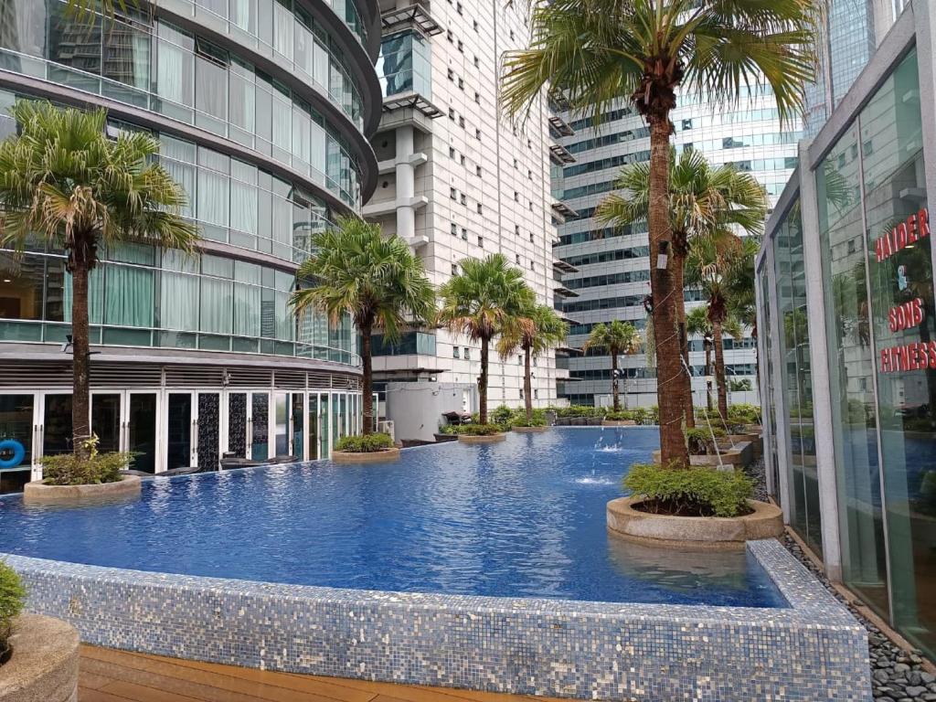 クアラルンプールにあるKLCC Sky Villa Suites Vortexのヤシの木が茂る建物の中央にあるスイミングプール