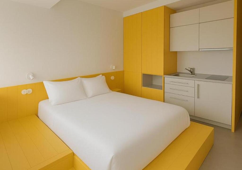 una camera da letto con un letto bianco e una cucina di Lisbon Serviced Apartments - Alvalade a Lisbona