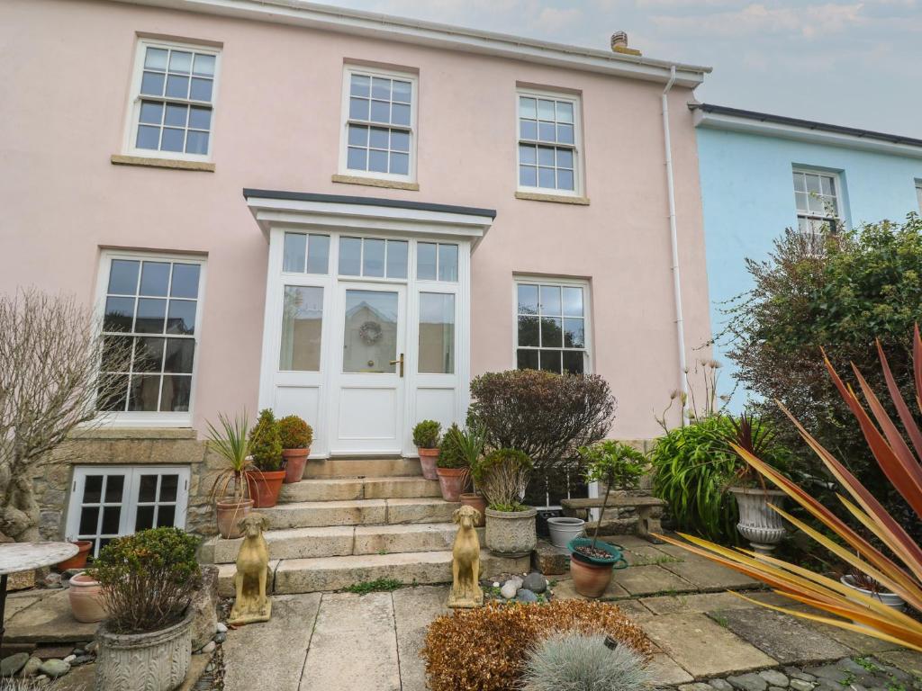a house with a white door and some plants at Scillonia in Penzance