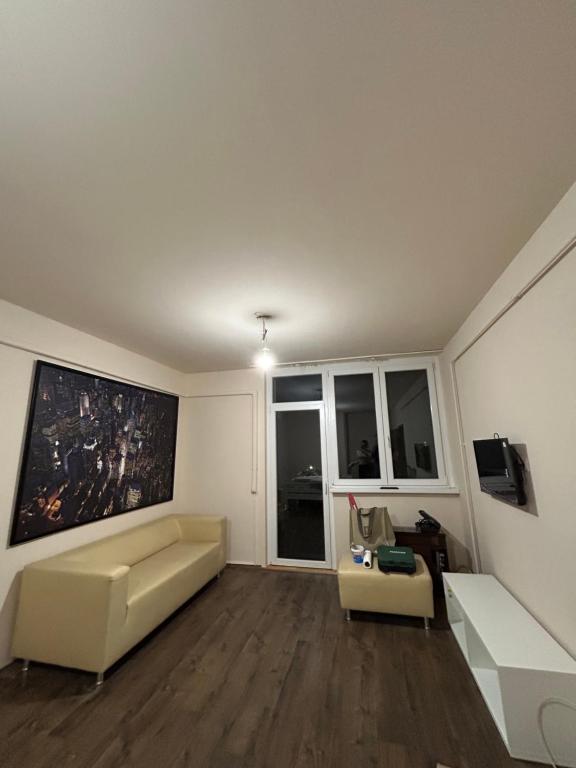 a living room with a couch and a tv at Szántó Prime Residence in Szolnok