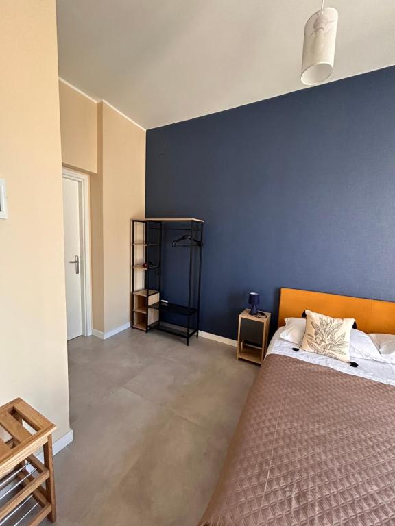 una camera da letto con un letto e una parete blu di Sesto Quaranta a Palermo