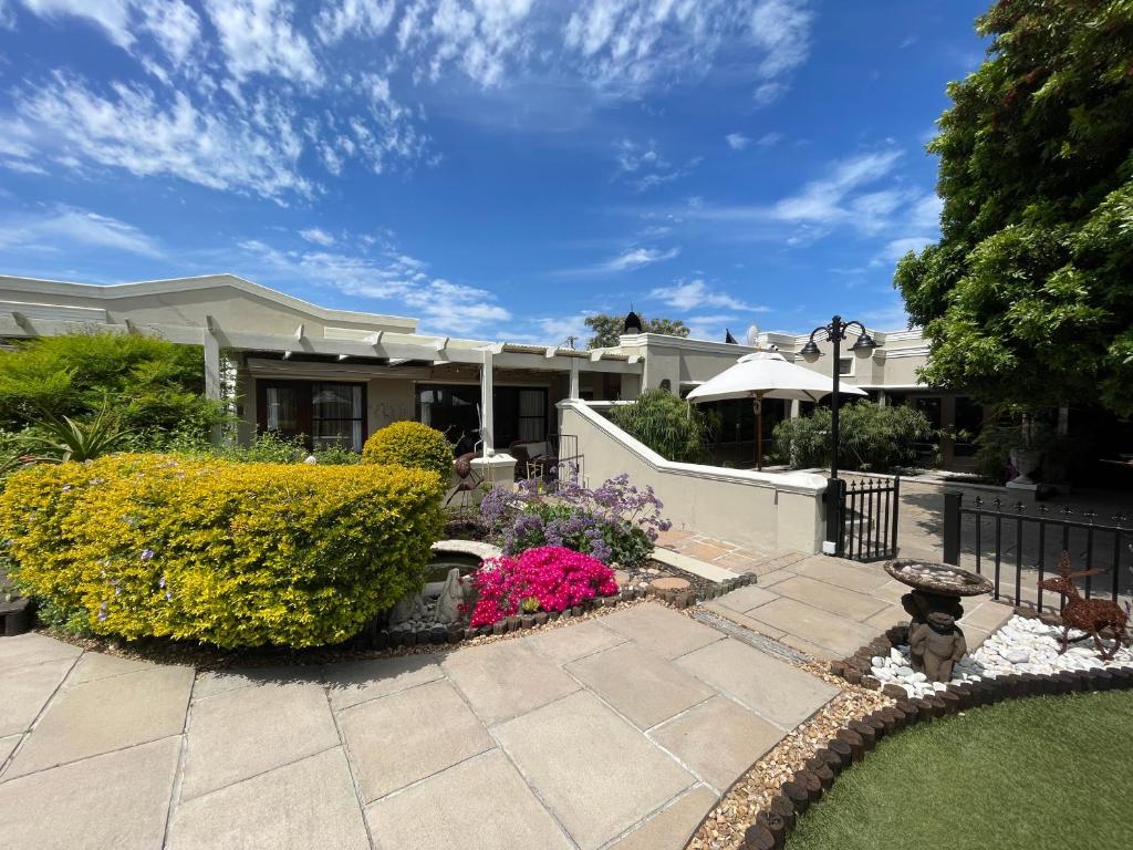 a house with a fence and flowers in the yard at Kaya La Provence in Cape Town