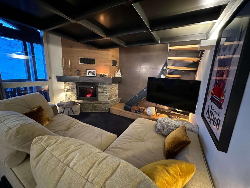 a living room with two couches and a tv at Luxury 4BR Apartment with Fireplace & Private Parking - Val Thorens in Val Thorens