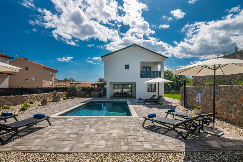 Villa con piscina, 2 sillas y sombrilla en Villa Taralis with heated pool, en Kaštel