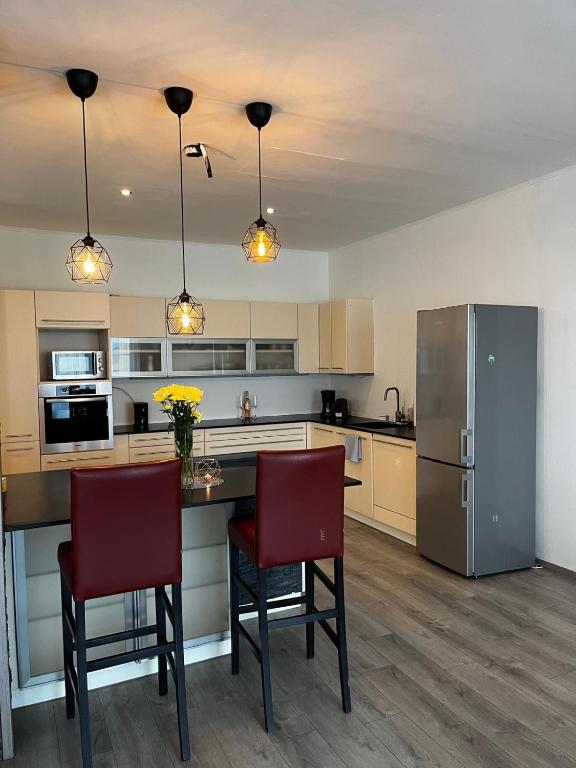 a kitchen with a table and two chairs and a refrigerator at Rohrbacher Herz II in Berg bei Rohrbach