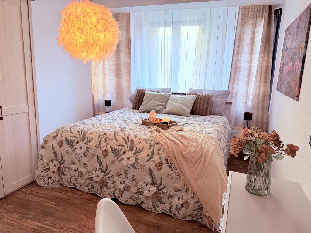 een slaapkamer met een bed en een vaas met bloemen bij BIELEFELD CITY APARTMENTS - Cozy in Bielefeld