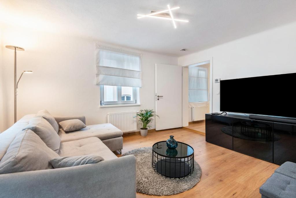 a living room with a couch and a flat screen tv at The Cozy Corner - Passau in Passau