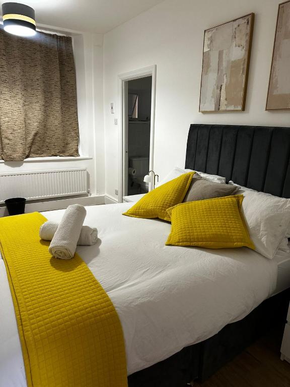 a bed with yellow and white pillows on it at Kingfield Boutique Hotel in Sheffield