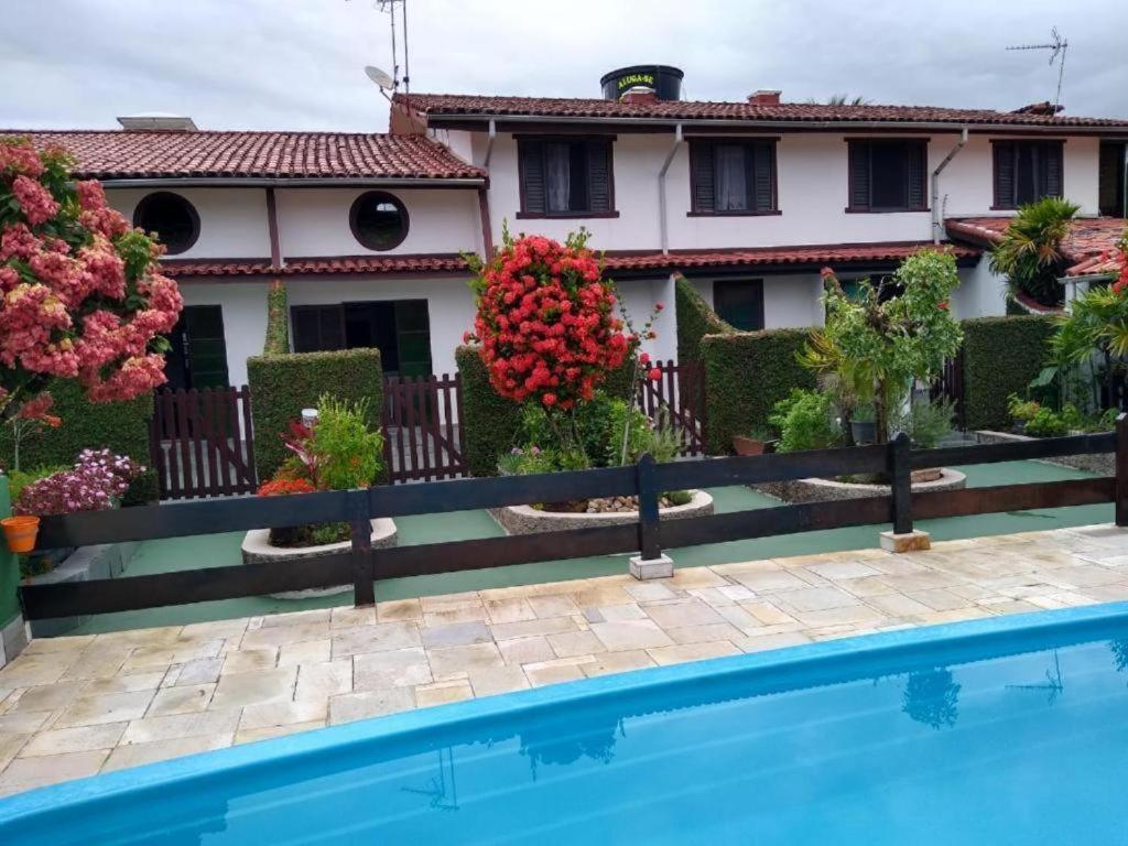 una casa con piscina delante de una casa en Sua casa na praia, comodidade, otima localização, en Caraguatatuba