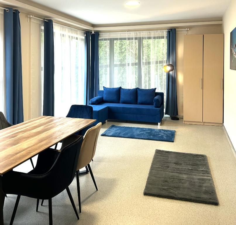 un salon avec une table et un canapé bleu dans l'établissement 4 hálószobás Pihenj Meg Vendégház, à Nyíregyháza