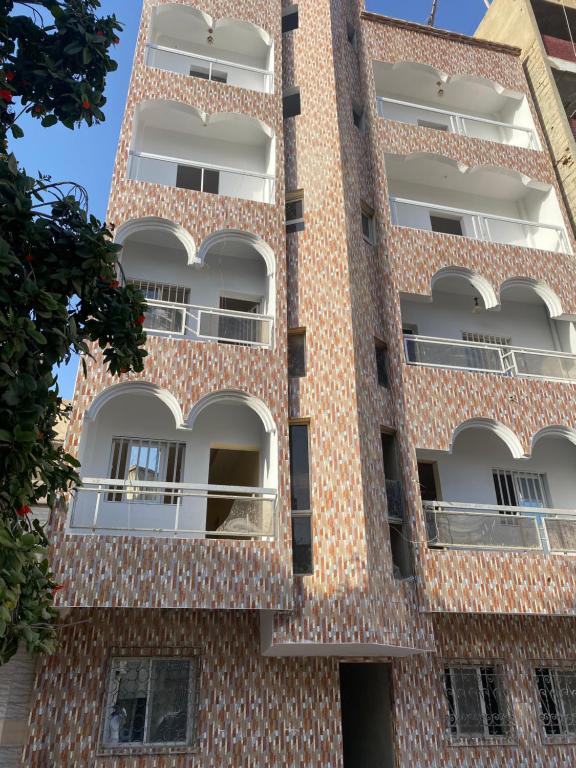 einen Außenblick auf ein Backsteingebäude mit Balkonen in der Unterkunft Nord foire studio meublé à Dakar in Dakar