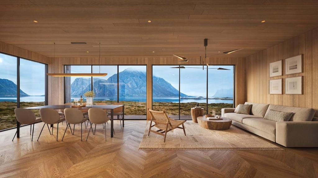 a living room with a table and a couch at Lodge 9 - Amazing cabin in Lyngvær in Storøya