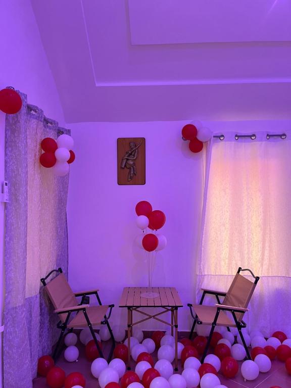 une pièce avec deux chaises et des ballons rouges et blancs dans l'établissement ambayard, 
