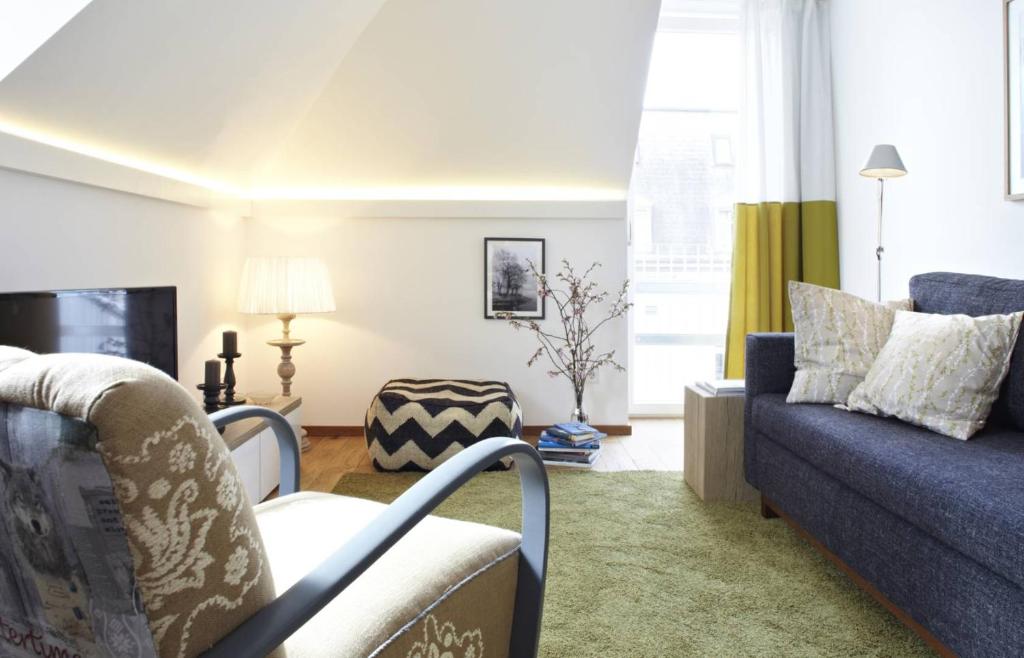 a living room with a couch and a chair at KönigsSCHLAF No3 - Die Große mit Balkon in der Konstanzer Altstadt in Konstanz