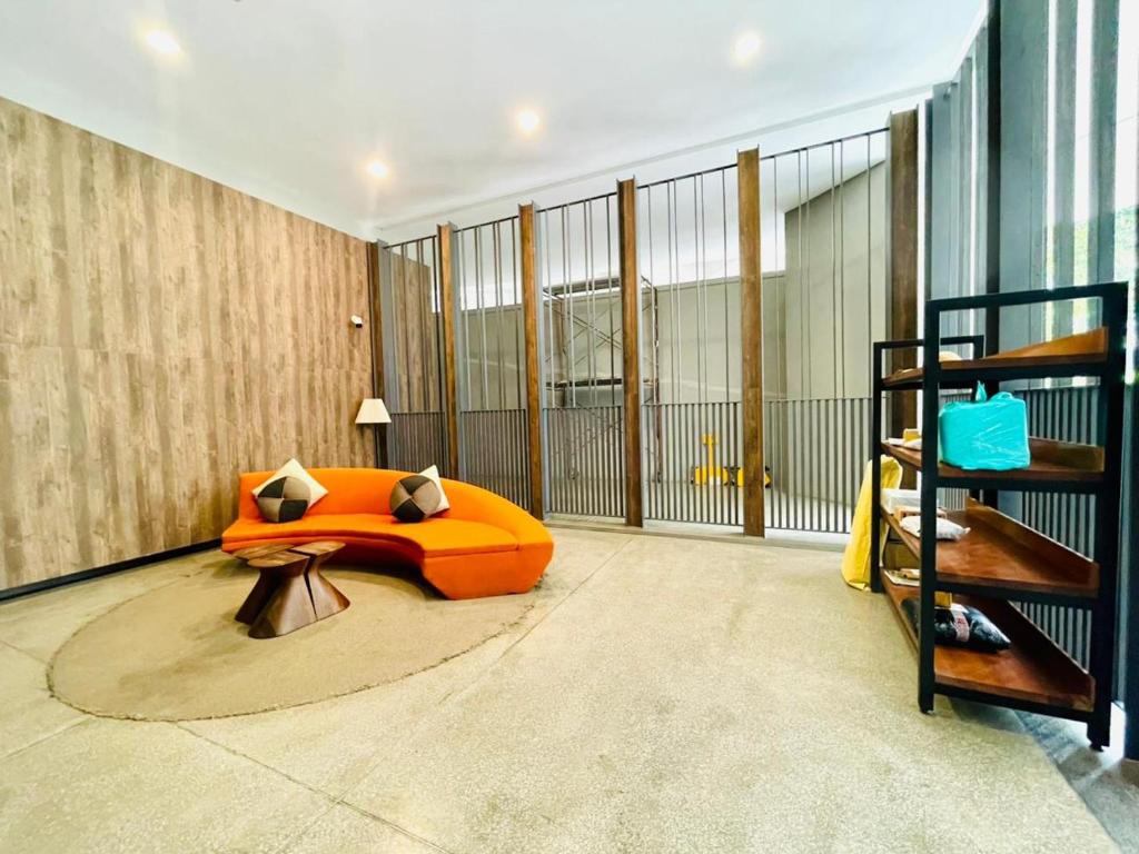 a living room with an orange bed and a staircase at KLCC Sky Villa Suites The Mews in Kuala Lumpur