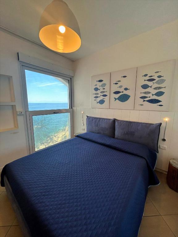 a bedroom with a blue bed and a window at Casa Pomonte in Pomonte