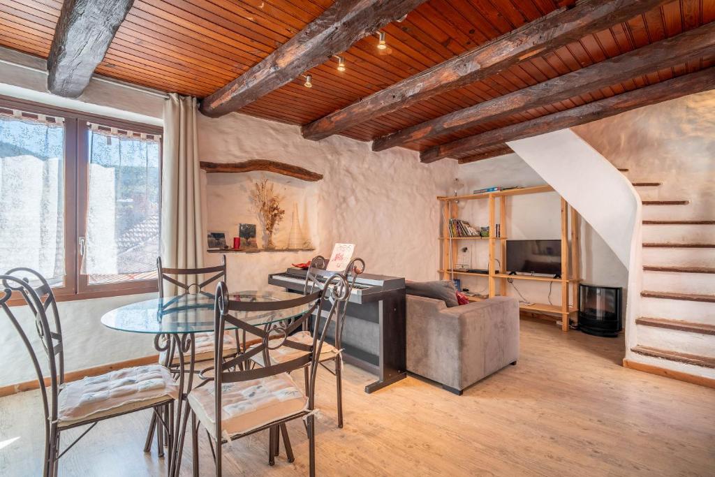 a living room with a glass table and chairs at Maison dans Village médiéval in Olargues