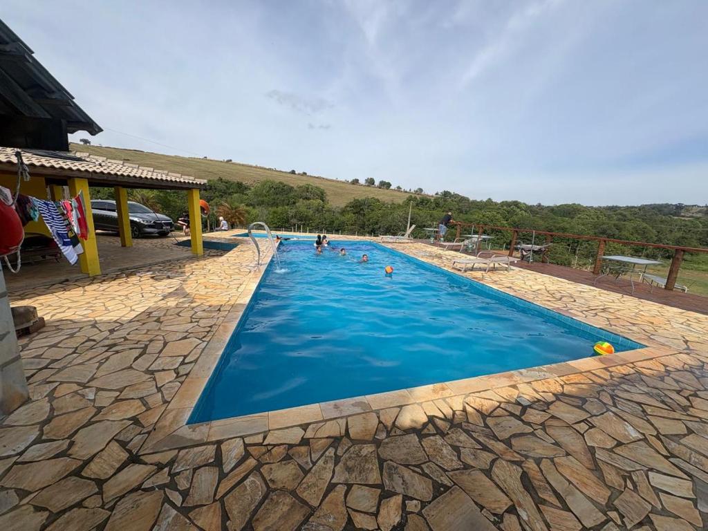 una piscina con agua azul y gente en ella en Sítio Lopes, en Toledo