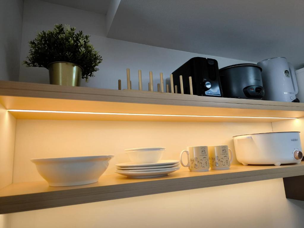 a shelf with bowls and plates and utensils on it at Prime Zen in Silang
