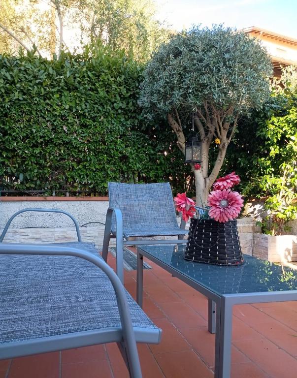 two chairs and a table with a tree on it at Fienile Paradiso Home Tuscany in Campi Bisenzio