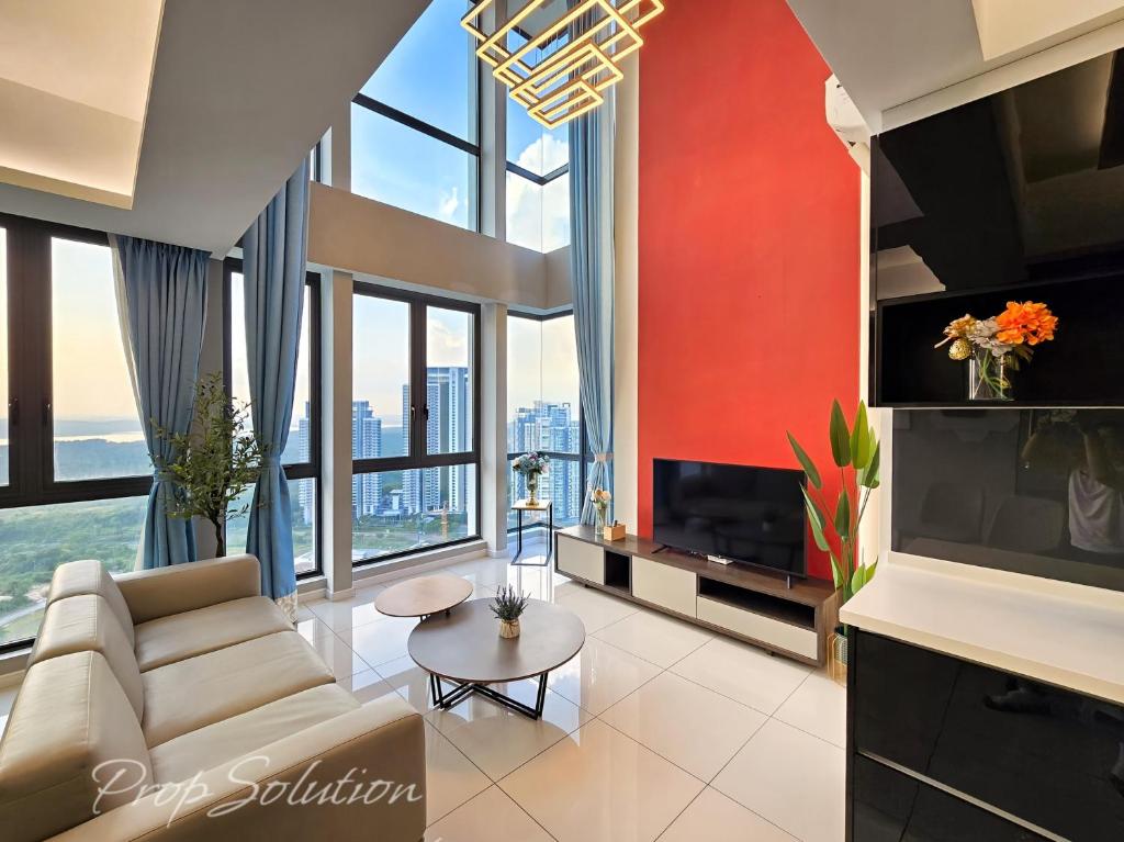 a living room with a couch and a tv at Spacious Cozy Elysia Suite Johor Bahru Legoland in Iskandar Puteri