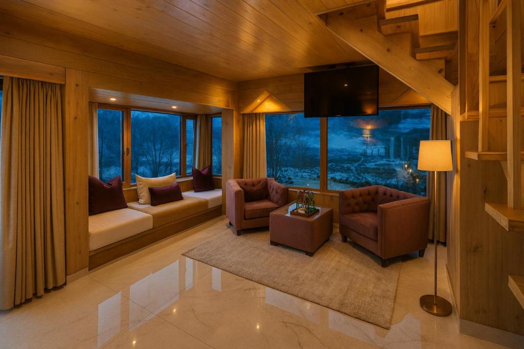 sala de estar con sofás, TV y ventanas en Himalayan Fort Resort, Manali - !! Riverside Property !! Big Garden with Campfire !! Guest Preferred !! Scenic River & Mountain View !! Big Parking !! Luxury Balcony Rooms !! Playing Zone !! Property of the Year, en Manali