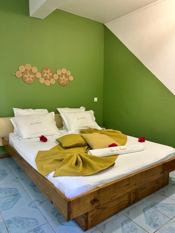 a bed with white sheets and red flowers on it at steila-Day hébergement chambre privée in Pamandzi