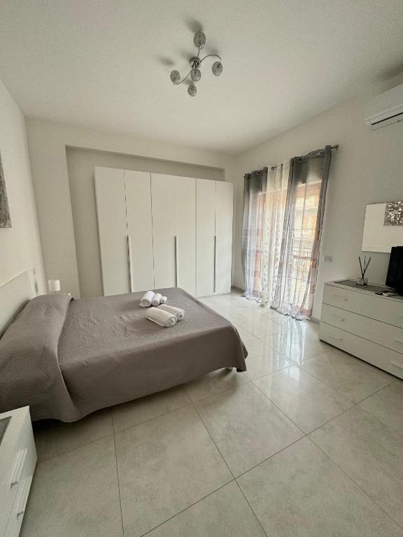 Un dormitorio con una cama y una cómoda y una ventana. en Suite Gelsomino, en Caulonia Marina