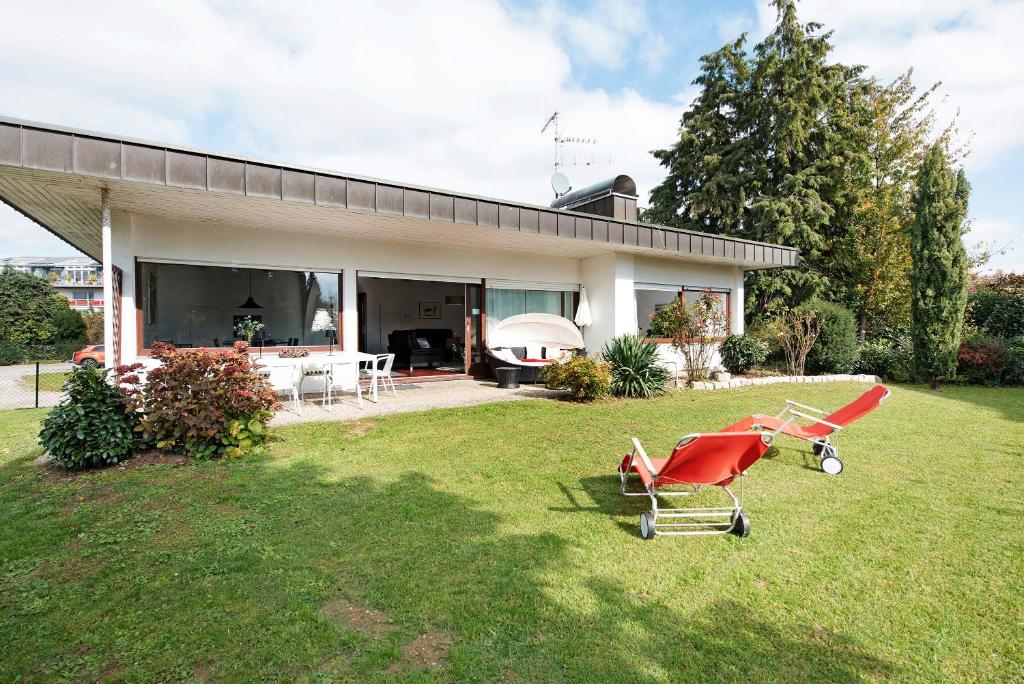 a house with a red chair in the yard at Bodensee Bungalow in Immenstaad am Bodensee
