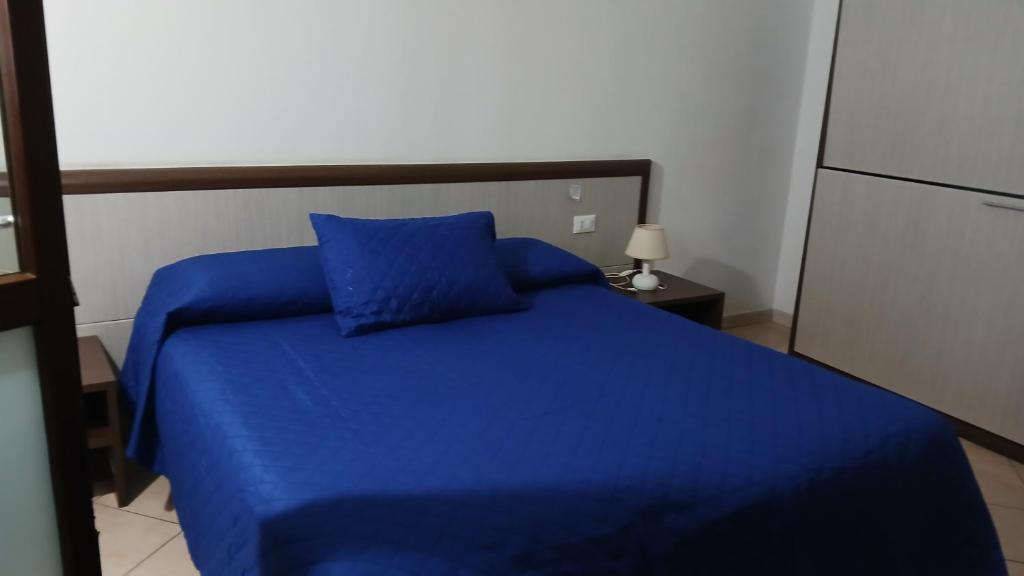 a blue bed with a blue pillow in a room at Domo - Guest-House Il Nespolo Fiorito in Orosei