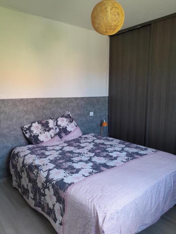 una camera da letto con un letto grande con una coperta viola di Chambre paisible à la campagne a Sarrouilles