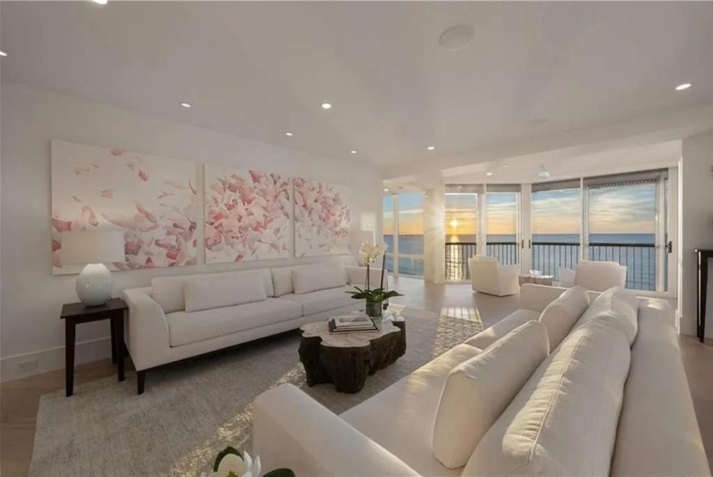 a living room with white furniture and a large couch at Gulf-front Masterpiece in Naples