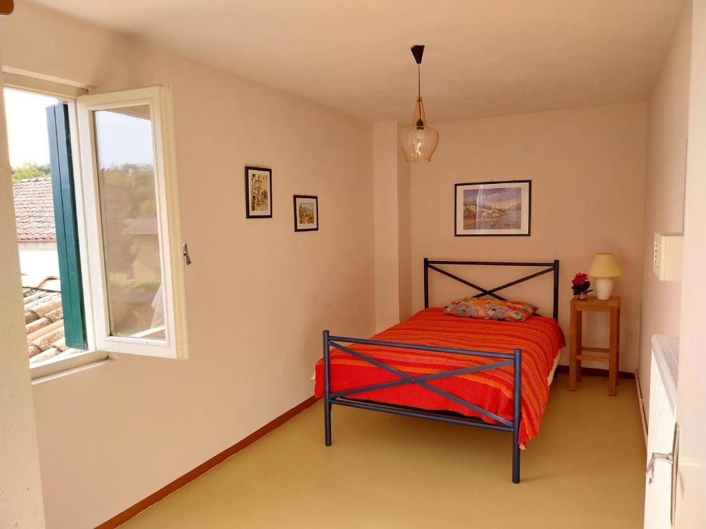 Un dormitorio con una cama roja y una ventana. en Family House on private courtyard in Fanna, en Fanna