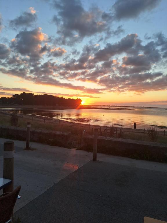 a sunset on a beach with the sun setting at Benabeach in Sarzeau