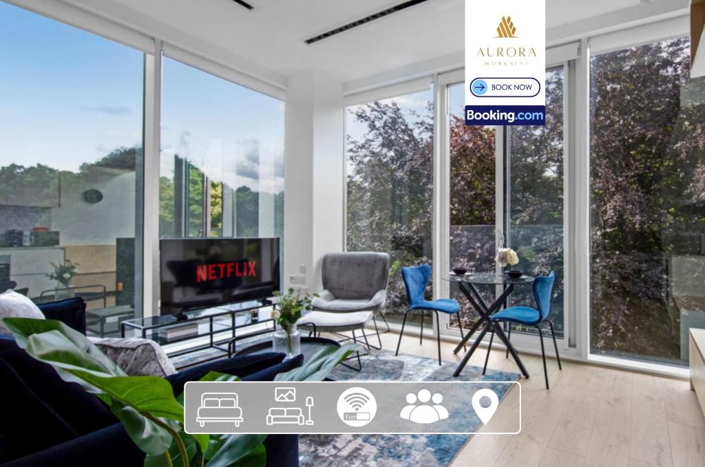 ein Wohnzimmer mit Sofa, Stühlen und Fenstern in der Unterkunft Stylish 2BDR Apartment With Cinema, Gym and Free Parking By Aurora WorkNest Short Lets & Serviced Accommodation London in Kew Bridge