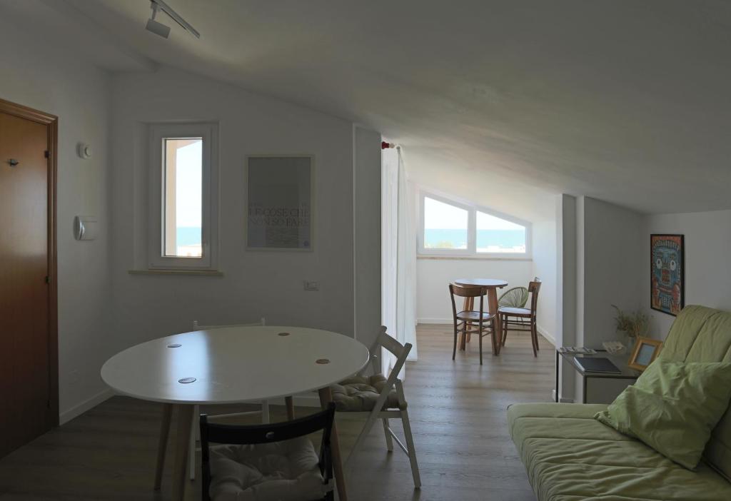 a living room with a table and a couch at sottotetto sul mare in Potenza Picena