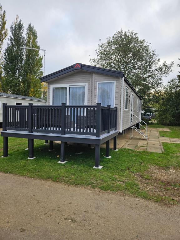 una casa móvil con un banco en el césped en Billing Aquadrome Holiday Park Fishing Lakes Gold Caravan, en Great Billing