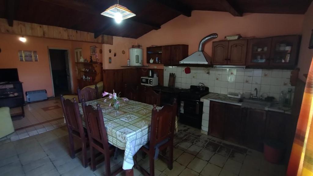 cocina con mesa y sillas y cocina con fogones en La casa de David, en Deán Funes