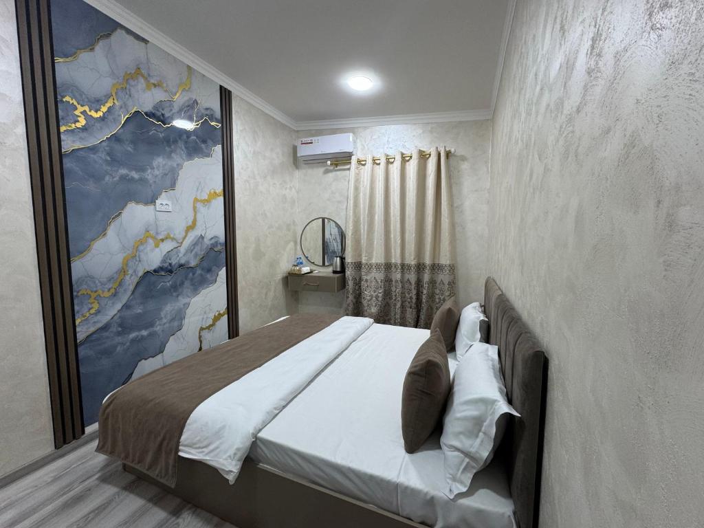a bedroom with a bed with a large painting on the wall at Art Home in Tashkent