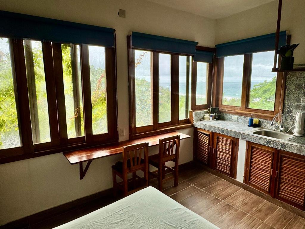 a kitchen with windows and a counter with a sink at Estudio con vista al mar, AC, WIFI Starlink, Parking in San Agustinillo