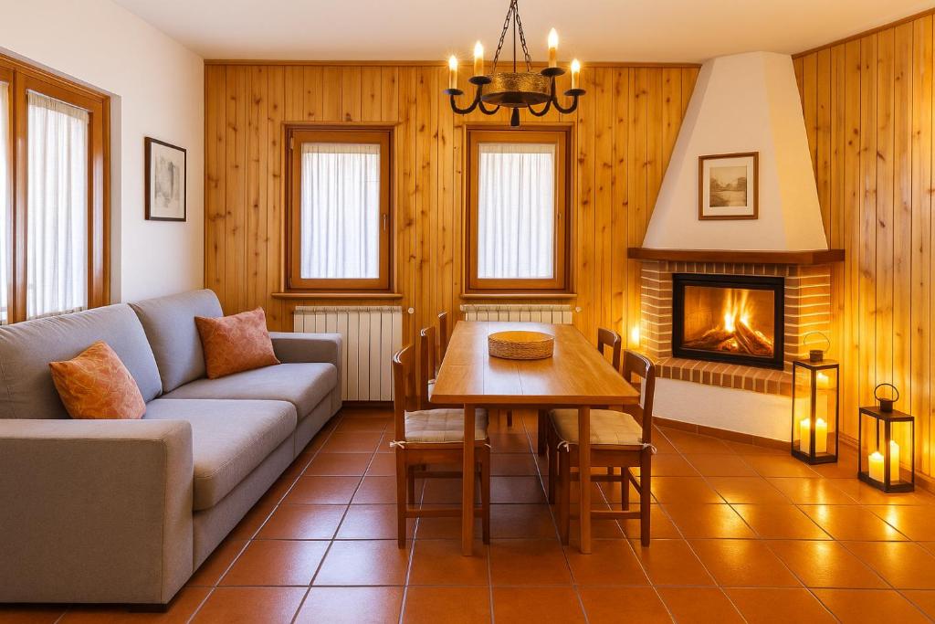 a living room with a couch and a table and a fireplace at Chalet Mary Roccaraso in Roccaraso