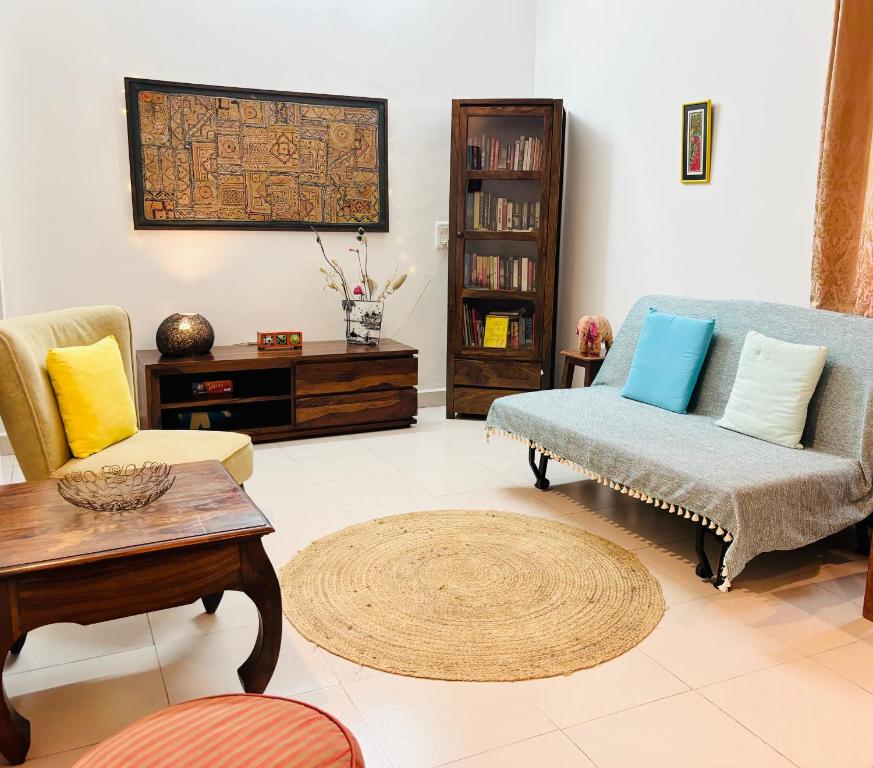 a living room with a couch and chairs and a table at The YelloMello House 1BHK fast Wi-Fi AC Pet-Friendly Cosy Cottage in Mandrem