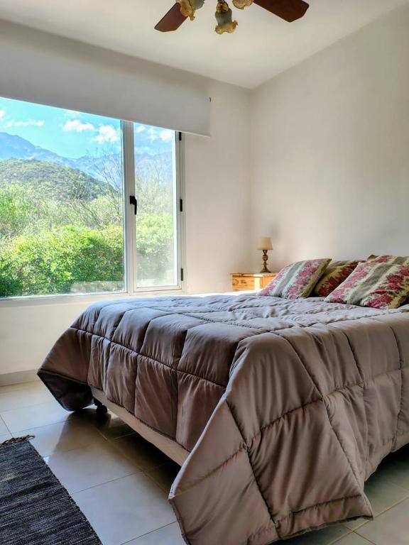 a bedroom with a large bed with a large window at Cabaña La Raquela in La Paz