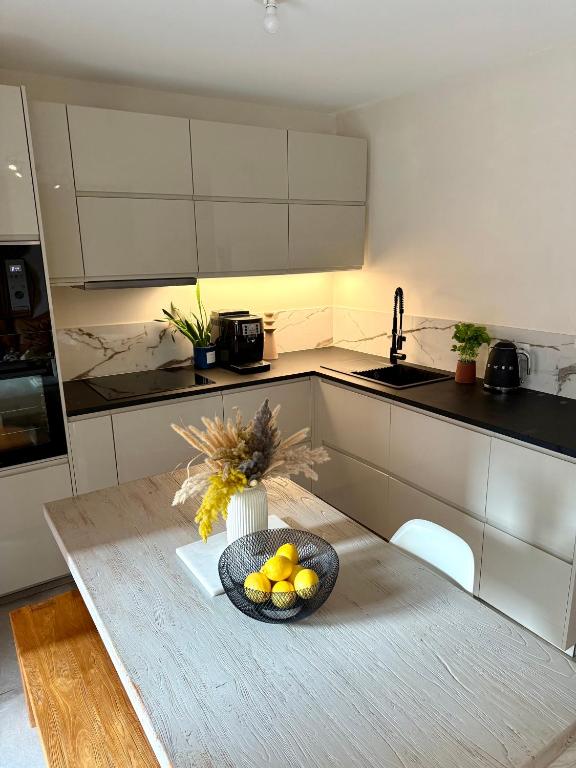 a kitchen with a bowl of fruit on a table at Malakoff - 3 pièces avec terrasse in Malakoff