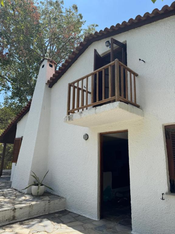 a white house with a balcony on top of it at Villa Anna in Kalamos