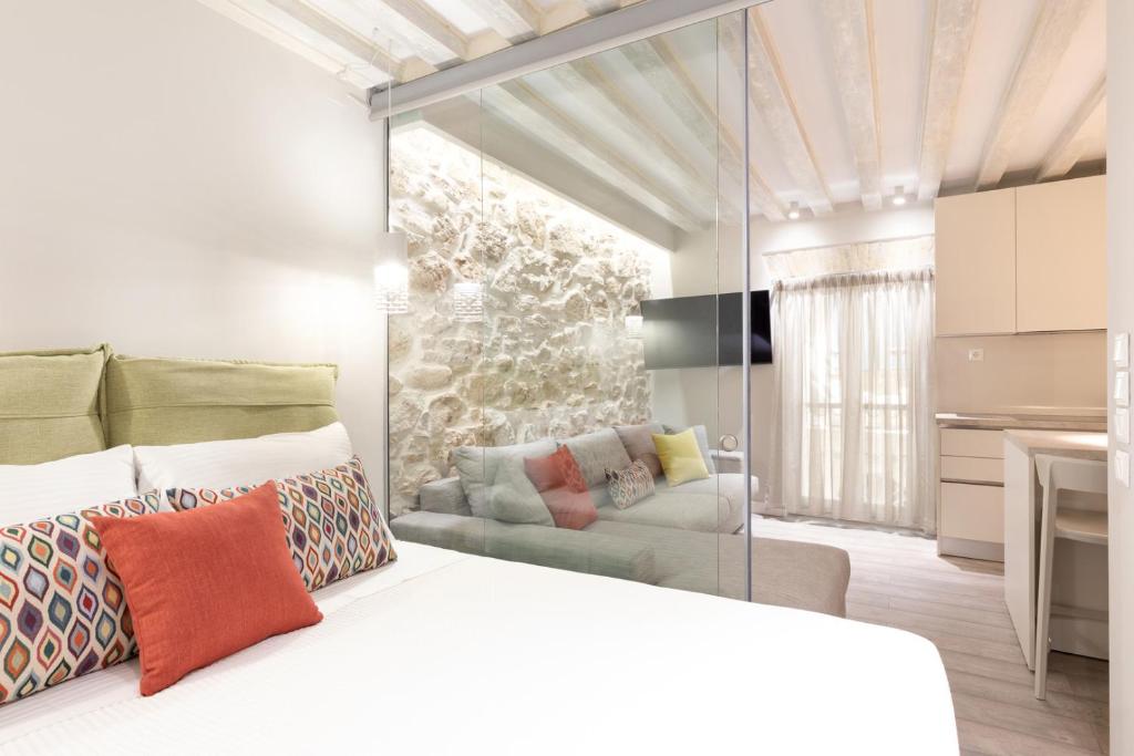 a bedroom with a white bed and a couch at Petite Town Hall Apartment by Konnect, Old Corfu Town in Corfu Town
