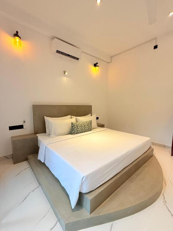 a bedroom with a large white bed in a room at The Green Loft Rooms in Ahangama